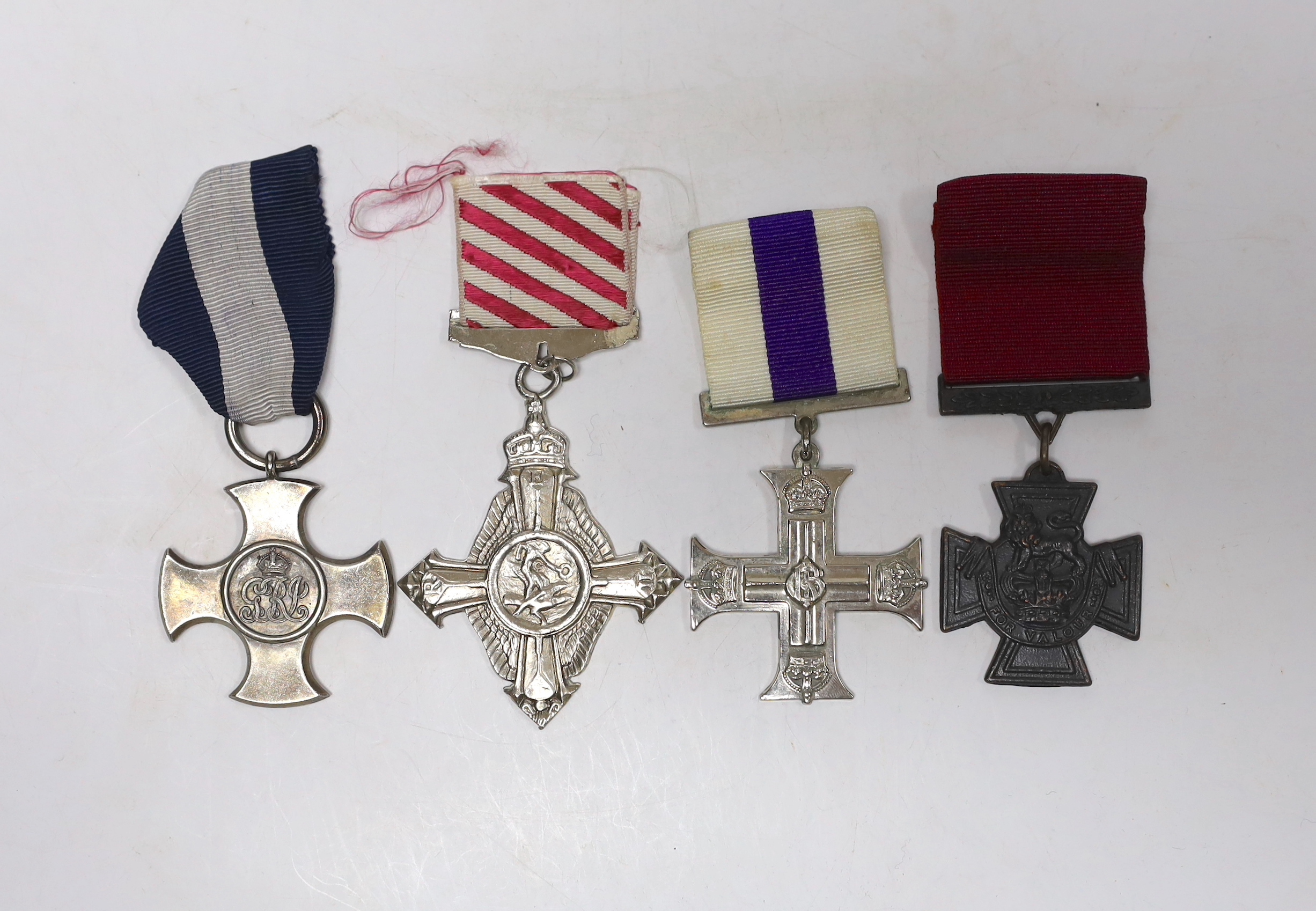 Four well produced replica medals. A Victoria Cross, a Distinguished Service Cross, a Military Cross and an Air Force Cross